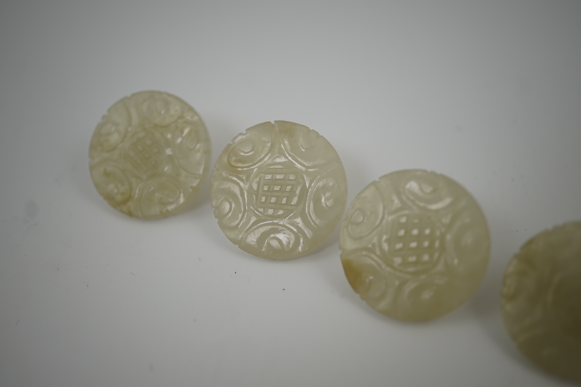 A set of five Chinese pale celadon jade robe buttons, 19th century